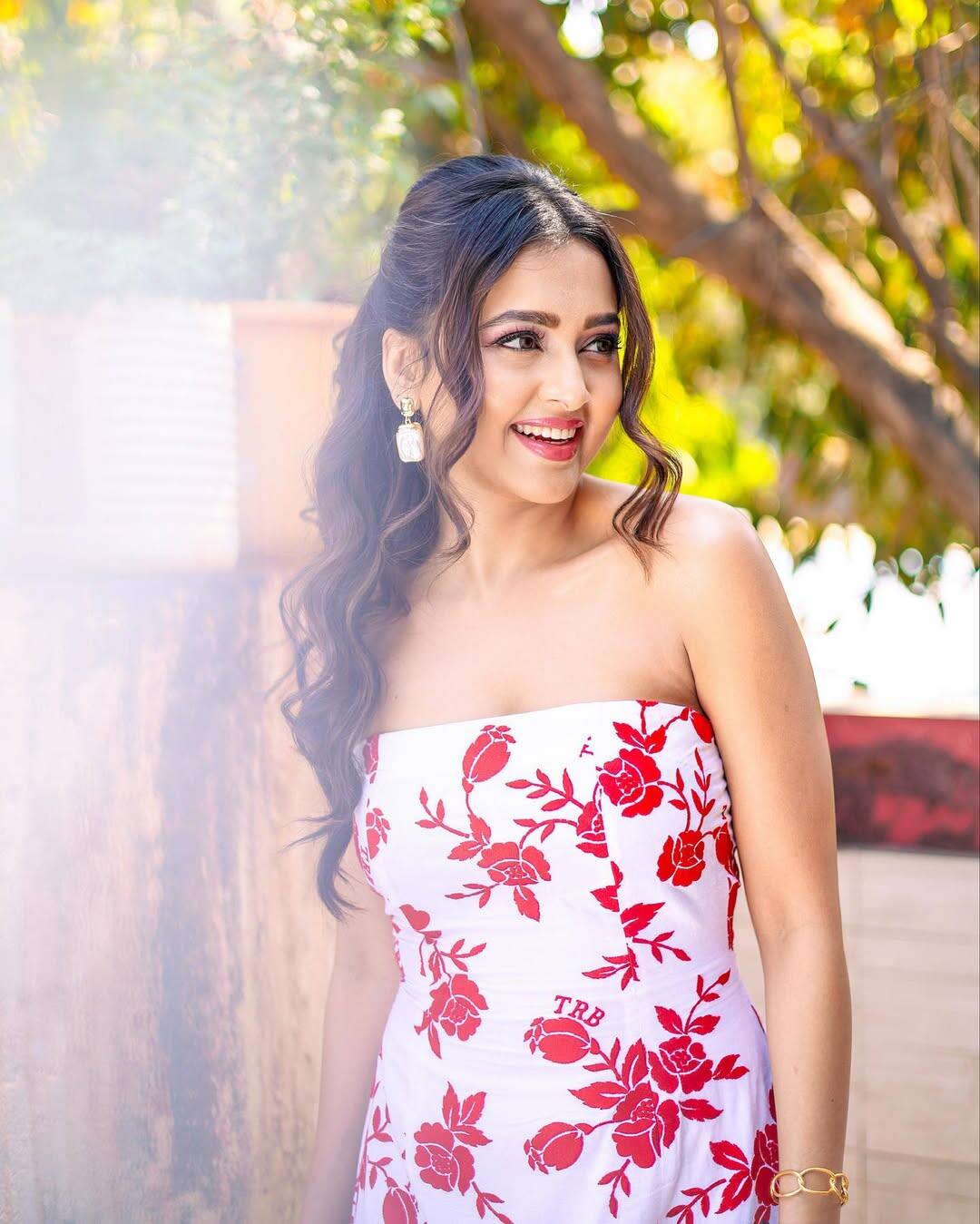 Tejashwi looks very fresh and summer in this look. He is wearing a white colored strapless dress on which there is a printing of red flowers. Open wavy hair, golden earrings and bracelets have beautifully completed his look.