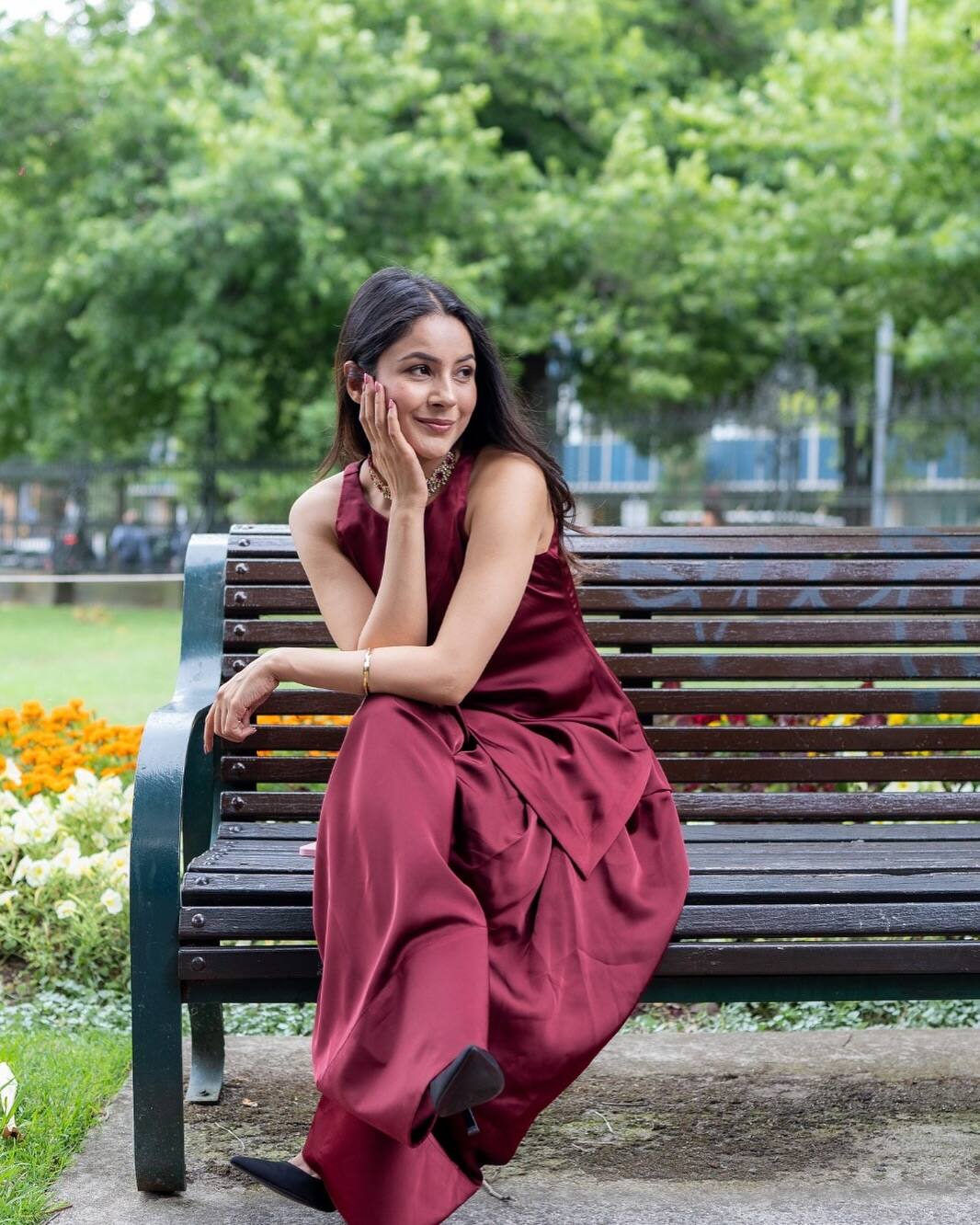 In this look, Shahnaz is wearing a maroon color silk dress, giving her a royal look. She is completing the look with a stylish neckpiece in her throat, simple brasslets, open hair and natural makeup.