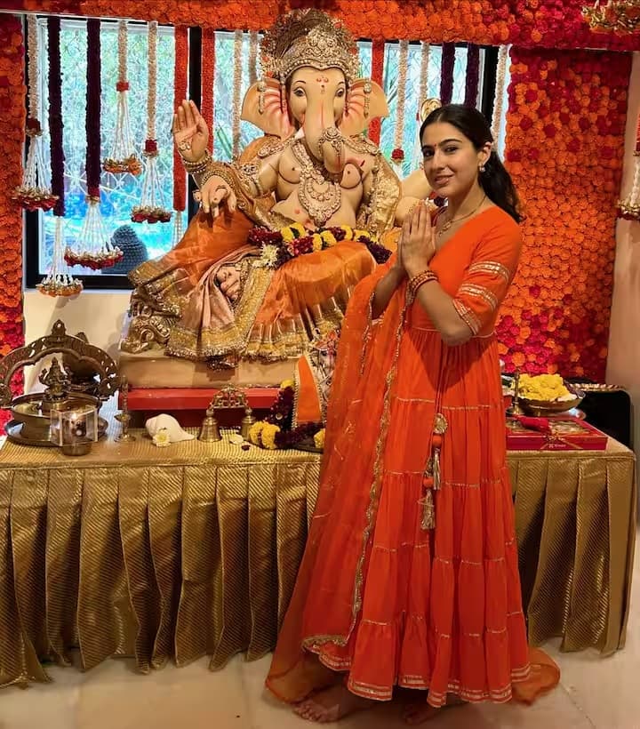 सारा का लुक पूरी तरह से गणेश चतुर्थी से प्रेरित है। चटक नारंगी और सुनहरे रंग का यह कॉटन अनारकली सूट पूरी तरह से त्यौहार जैसा एहसास दे रहा है। इसके अलावा, सारा ने अपने लुक को एक साधारण बिंदी और छोटे झुमकों से पूरा किया है।