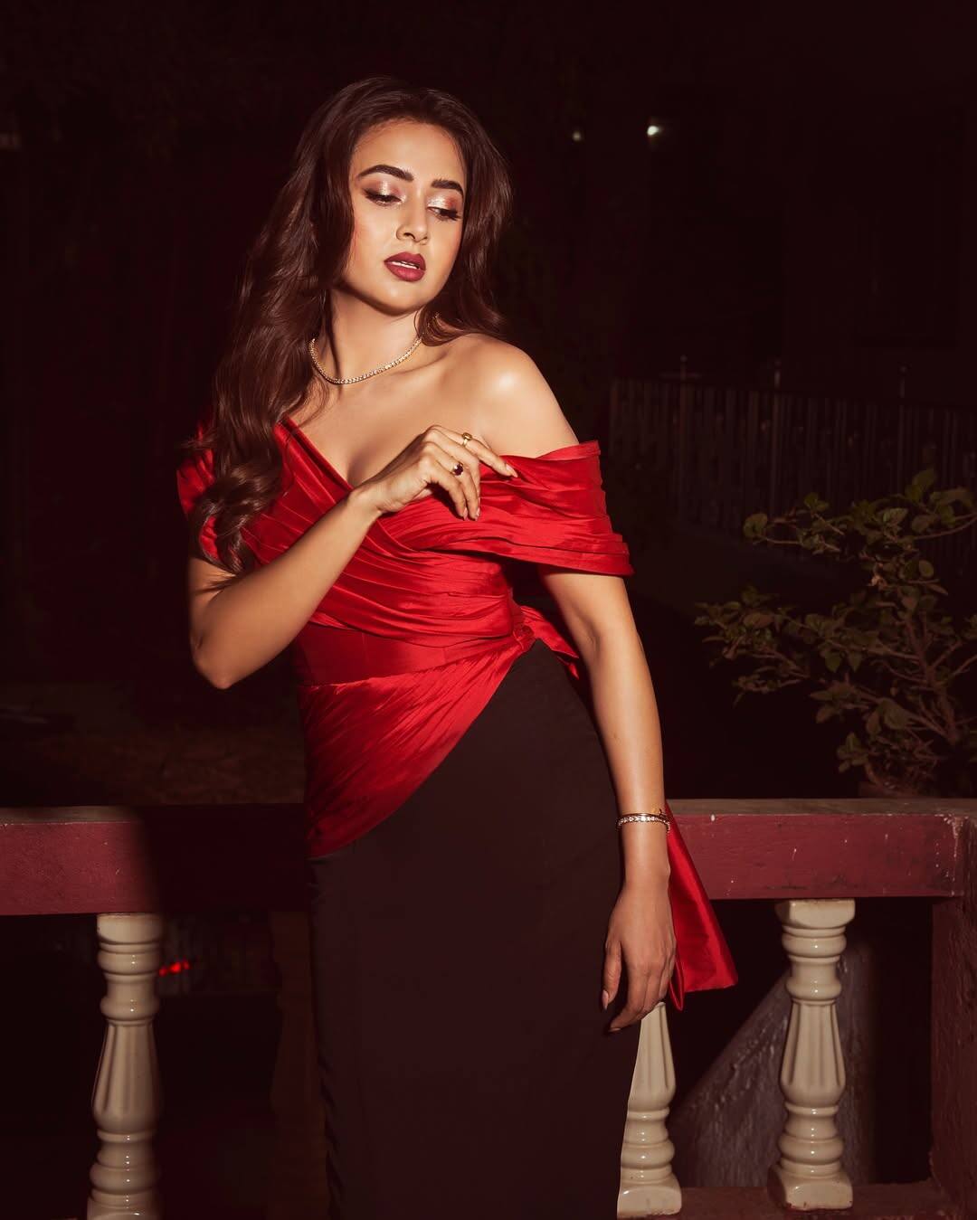 Tejashwi has carried a maroon skirt with off-shoulder red top. Smokey Eye makeup, nude tone highlight, dark red lipstick, open long hair and minimal jewelery are making their entire look to put the entire look.