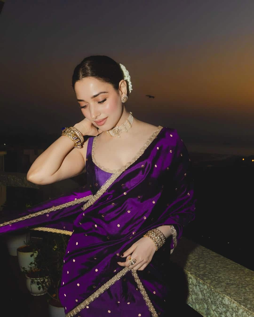 In this, the actress is wearing a silk saree of dark purple color, on which the golden border and design are visible. They have carried it with sleeveless blouse. The hair is tied back in middle parting and is decorated with white gajra. Makeup is very natural and satal, due to which her look looks very elegant and royal.