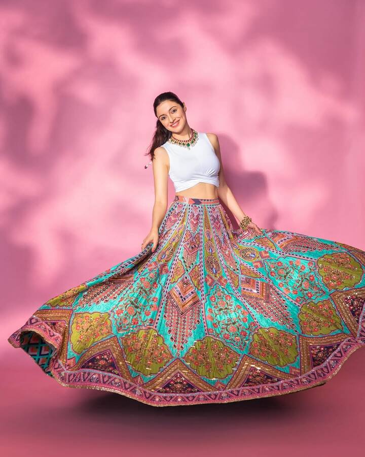 Divya, wearing a printed skirt with a white crop top, looks quite classy. She has styled this dress with multi -color necklace.