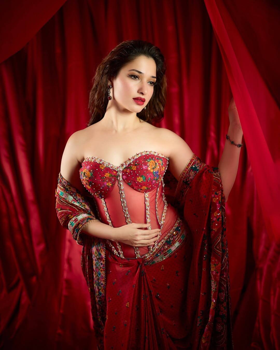 The actress is wearing a very stylish and glamorous outfit of red color, which is with a corset style top and has been done on a multicolor embroidery. Along with this, he has also taken a matching scarf. Their open curly hair and nude makeup looks more beautiful. In this look, the actress looks quite confident and glamorous.