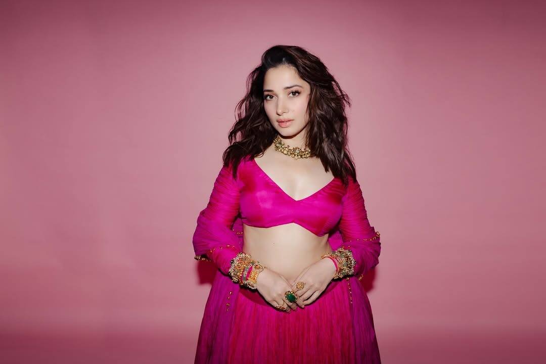 In this picture, the actress is wearing a traditional outfit of pink color. He has carried it with full sleeves blouse and matching skirt. Open wavy hair and nude makeup are highlighting their natural beauty. In this look, she looks quite simple, cute and charming.