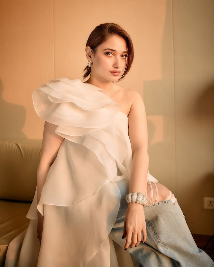 In this picture, the actress is wearing an off-shoulder top of white color, which she has carried with jeans. His look looks quite classy and glamorous. Light tone makeup is further enhancing her beauty, which makes her personality look even more attractive.