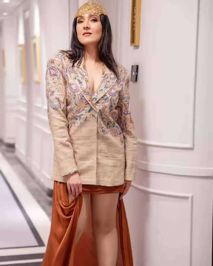 एम्ब्रॉयडर्ड जैकेट स्टाइल ड्रेस में टीना आहूजा का मॉडर्न लुक बेहद आकर्षक लग रहा है। खुले बाल और न्यूड मेकअप उनके आत्मविश्वास से भरे व्यक्तित्व को और निखार रहे हैं। यह तस्वीर उनके वेस्टर्न फैशन सेंस को बखूबी दर्शाती है।