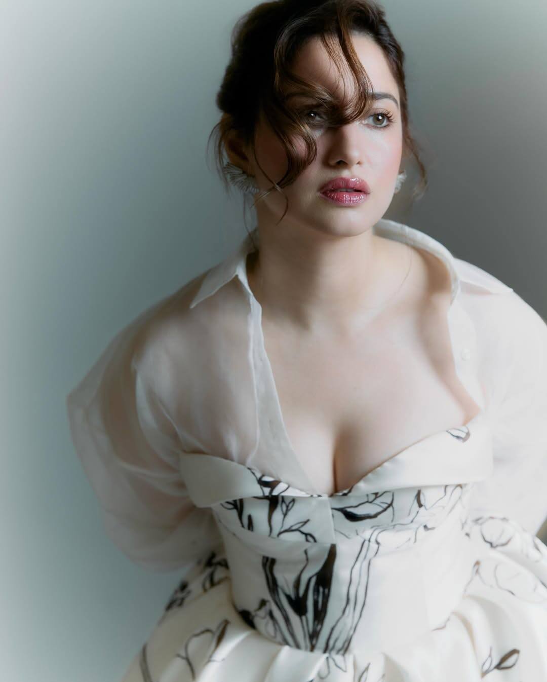 In this, the actress is wearing a deep neck dress with off-white and black floral prints. His nude tone makeup and light pink lips are making his look very classy and soft.