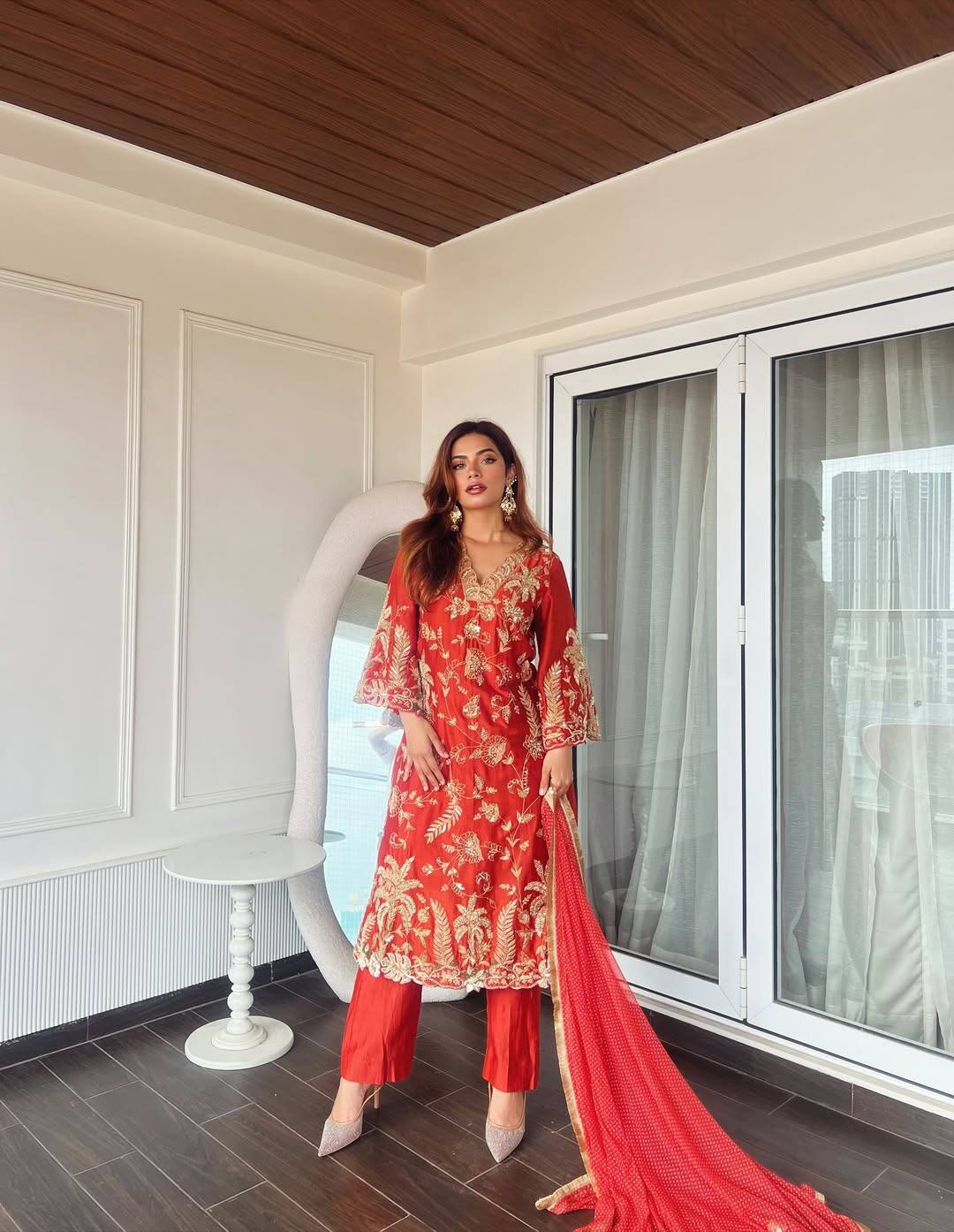 Nagma is carrying traditional in this look. He is wearing a red ethnic suit on which the work of golden embroidery is giving it a royal touch. With this, the matching plazo and red scarf are completing the entire outfit. He has styled this look with earrings, open hair and nude heels.