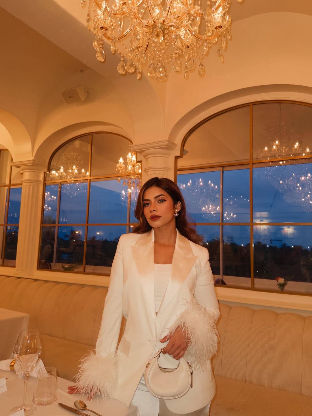 Nagma looks quite glamorous in this look. He is wearing an all-white outfit, with a satin finish blazer, on whose sleeves, the feather detailing is giving a luxury touch to his look. With this, he has carried white pants and small mini handbags. Dark lipstick and wavy hairstyle are making this look perfect.
