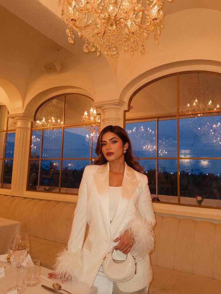 Nagma looks quite glamorous in this look. He is wearing an all-white outfit, with a satin finish blazer, on whose sleeves, the feather detailing is giving a luxury touch to his look. With this, he has carried white pants and small mini handbags. Dark lipstick and wavy hairstyle are making this look perfect.