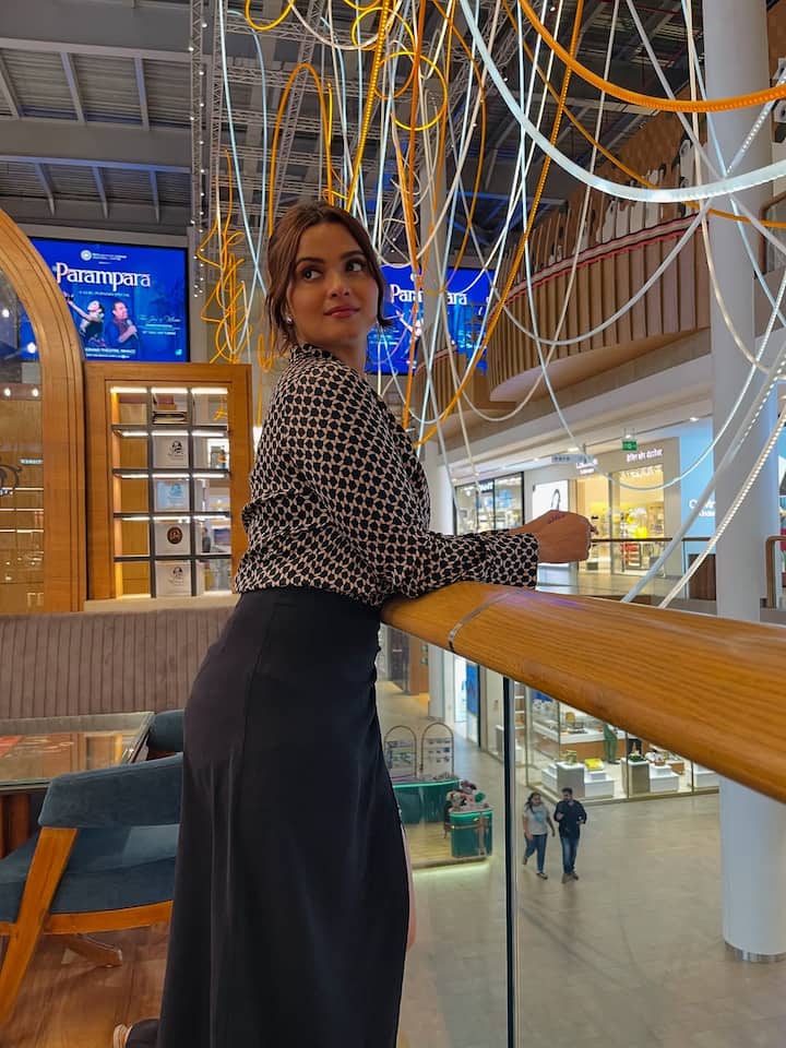 इस लुक में नीलम ने एक ब्लैक एंड व्हाइट प्रिंटेड शर्ट को ब्लैक हाई-वेस्टेड स्कर्ट के साथ पेयर किया है, जो उन्हें एक प्रोफेशनल लुक दे रहा है. हल्का मेकअप, न्यूड लिपस्टिक और बंधे हुए बाल इस लुक को थोड़ा सिंपल टच दे रहा है.