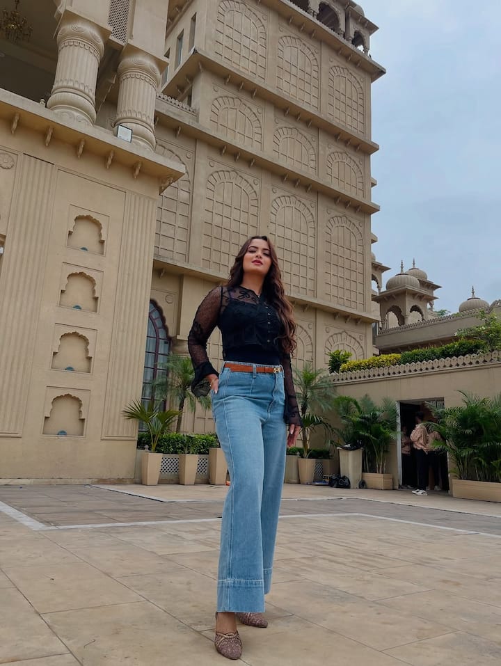 नीलम के इस लुक में उन्होंने वेस्टर्न लुक अपनाया है. उन्होंने ब्लैक नेट शर्ट पहनी है जिसे लाइट ब्लू वाइड-लेग जींस के साथ स्टाइल किया है. कमर पर ब्राउन बेल्ट आउटफिट में एक स्मार्ट टच दे रही है. पैरों में ग्लिटरी हील्स, खुले लहराते बाल और हल्का मेकअप उनके लुक को नैचुरल रख रहे हैं.