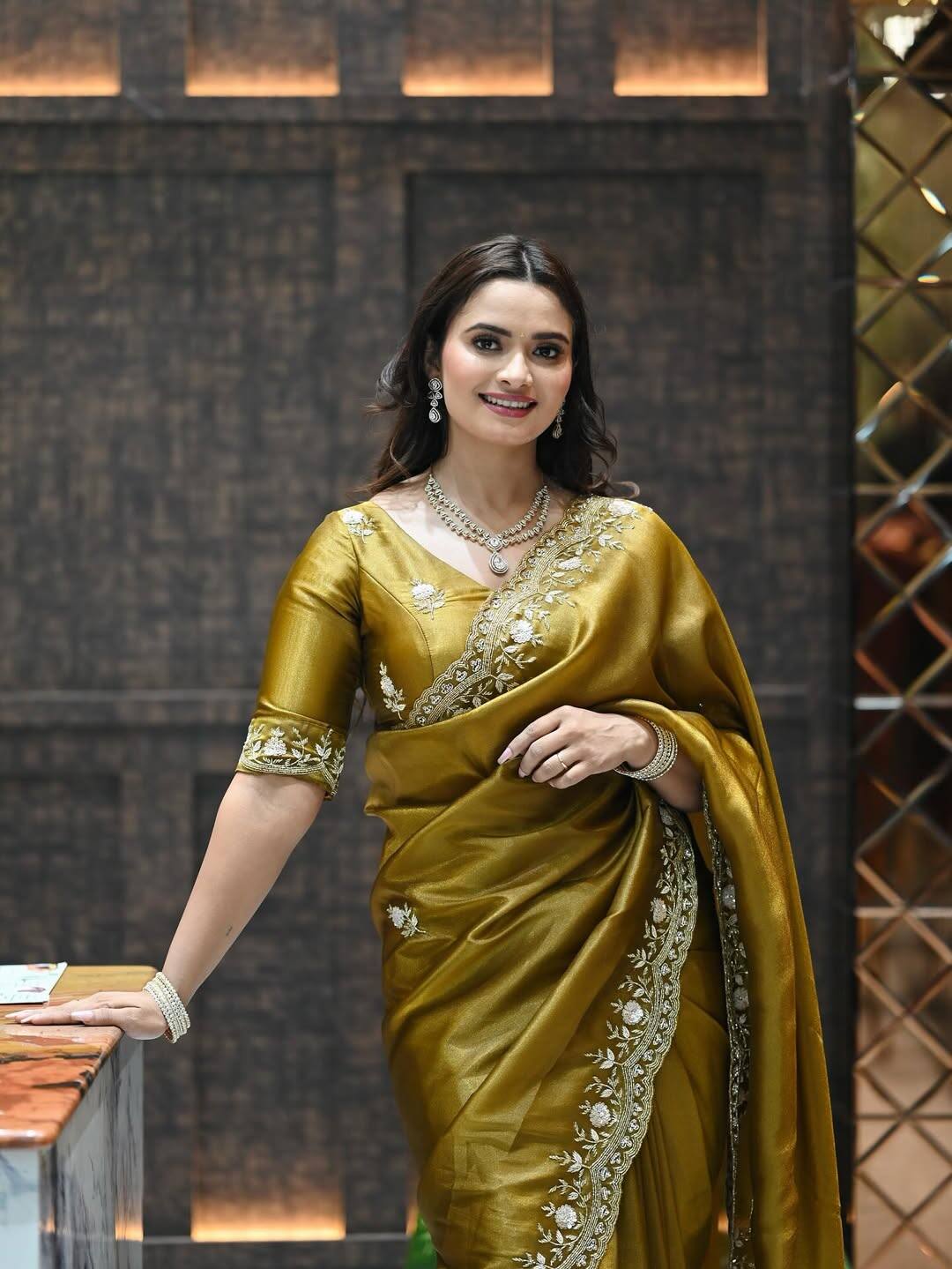 In this look of Neelam, she is wearing a golden colored saree, on which the work of embroidery with light golden threads has been done. He is wearing a matching blouse with it, which has also been finely embroidered. The necklace set of diamonds and beads around the throat, earrings in the ears and bangles in their hands are improving their looks.