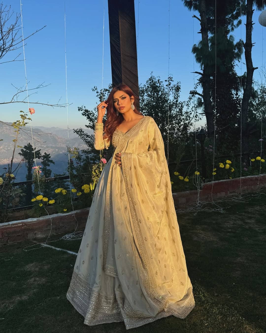 In this picture, Nagma is wearing a cream color heavy flare lehenga. With this, matching blouses and dupatta are making his look even more graceful. The light golden work on the outfit gives Royal Touch. Najma is looking very elegant and stylish with Oppan Wavy Hiresile and Nude Makeup.