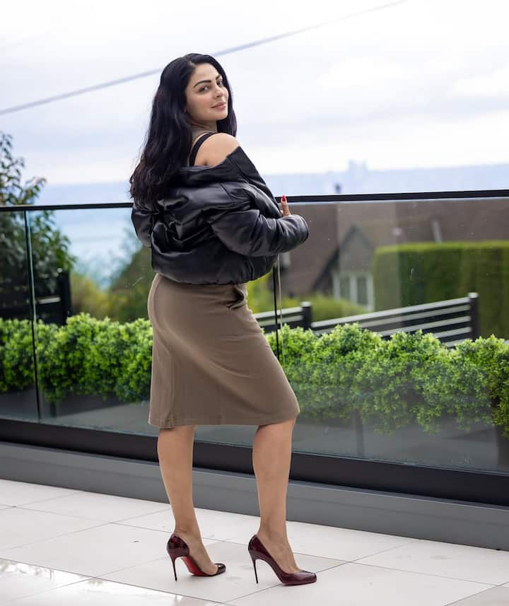 In this picture, Neeru Bajwa has carried a black color jacket with a bodycon dress. To give stylish touch to the look, she has worn high heels, which is making her whole style even more glamorous.