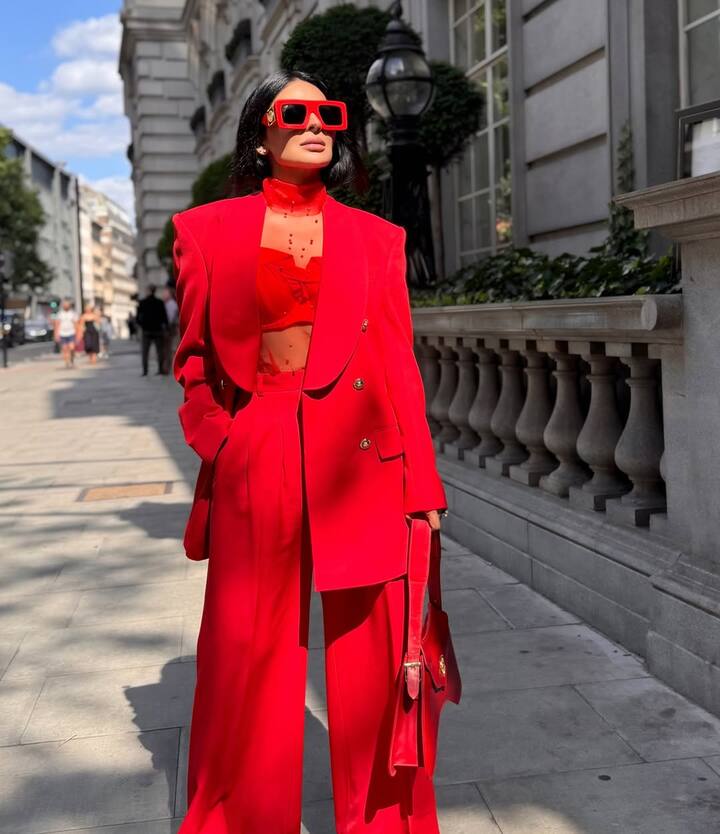 In this picture, actress is seen in a stylish look with red color pants and blazer. He has completed his look with goggles and matching bags. His confidant and classy style is making him even more smart and glamorous.