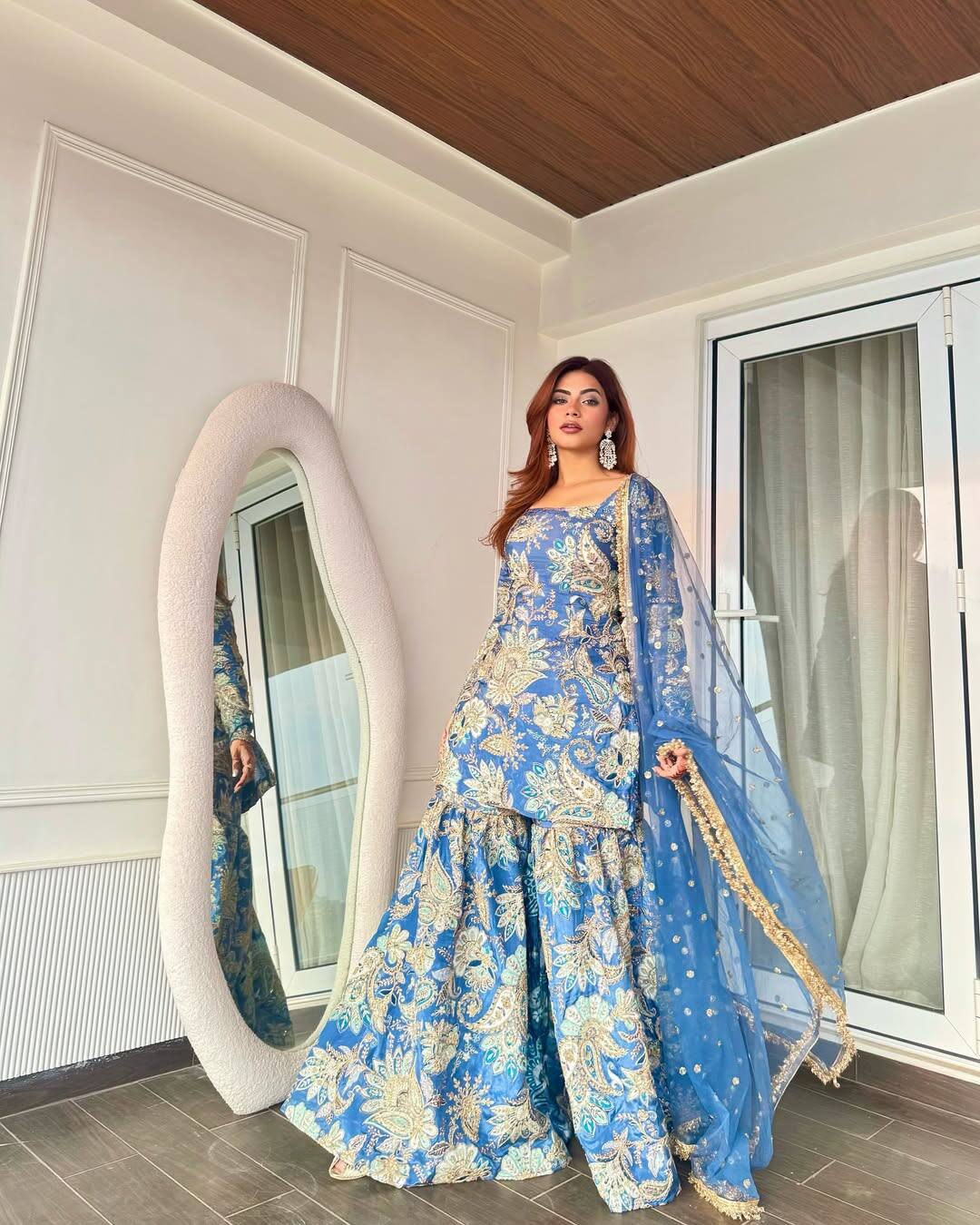 In this picture, Nagma is wearing a traditional sharara set with blue and golden prints. The golden floral embroidery performed on Sharara and Kurti is giving festive and grand touch to their entire outfits. With this, he has carried the matching blue scarf with the Golden border, which is giving him a simple and elegant look.