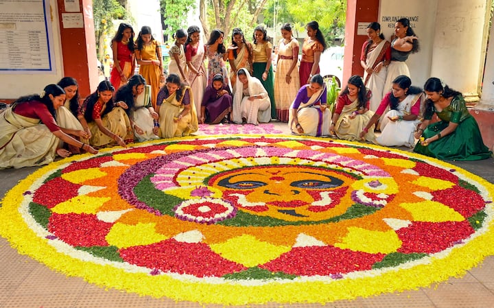 Among the most iconic traditions is the Pookalam—intricate floral designs laid at the entrance of homes, symbolising welcome and joy. Equally cherished is the Onam Sadhya, a grand vegetarian feast served on banana leaves, featuring a medley of flavors: rice, sambar, avial, thoran, pickles, and indulgent sweets like payasam. (Credit: PTI)