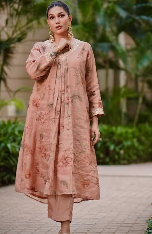 In this simple cotton suit, Sapna looks quite elegant. He has made a pony of his hair and is wearing big earrings in his ears. Sapna looks very cute in this look too.