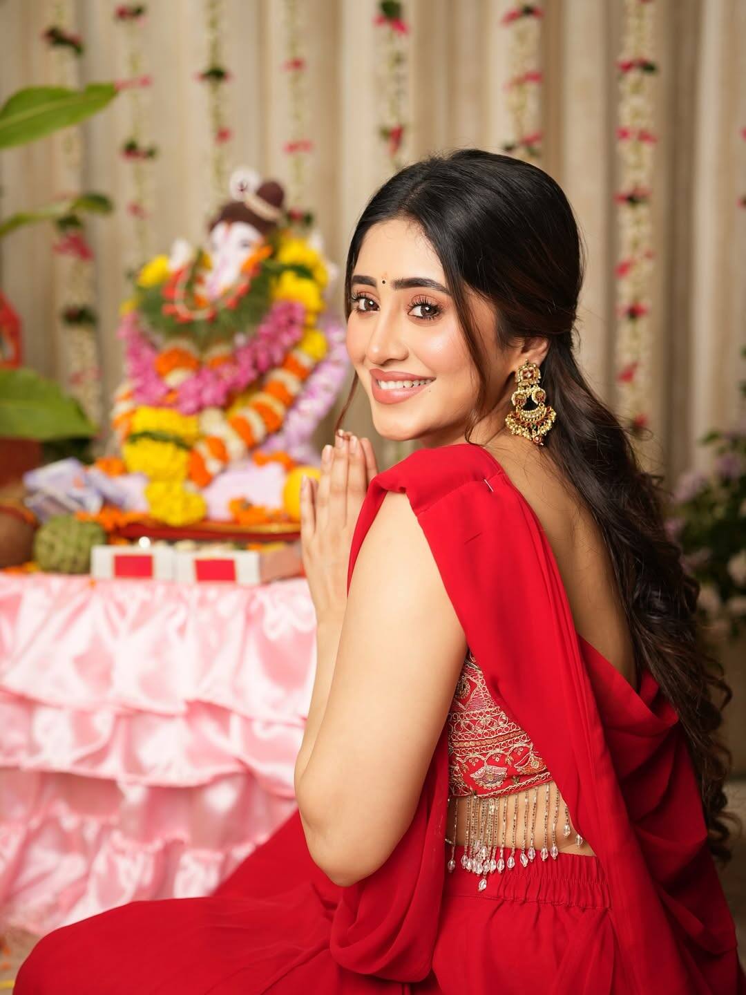 Shivangi Joshi in a red saree looks no less than a nymph. The actress is posing in front of Bappa with a big smile.