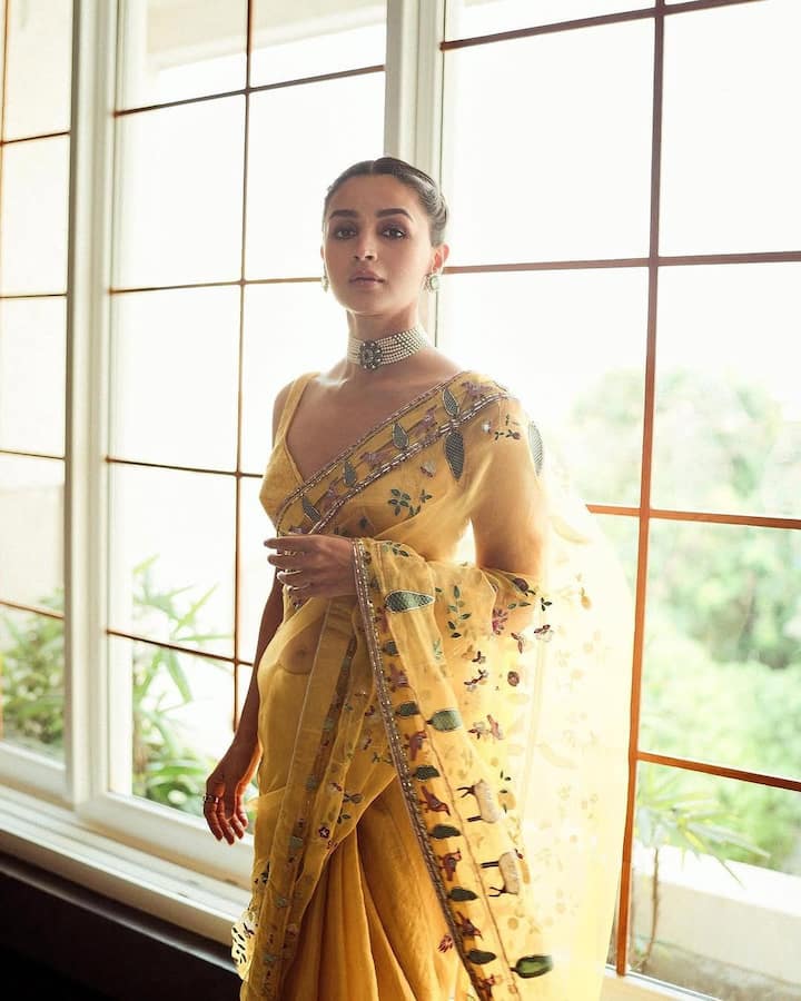 Like Alia Bhatt, you can also make your look even more beautiful by paying bran with your saree. You can carry pearl bran with both Indian and Western outfits. Here Alia has a white bran pair with Yellow designer saree and is wearing light earrings in the ears. In this whole look, the actress looks really beautiful.