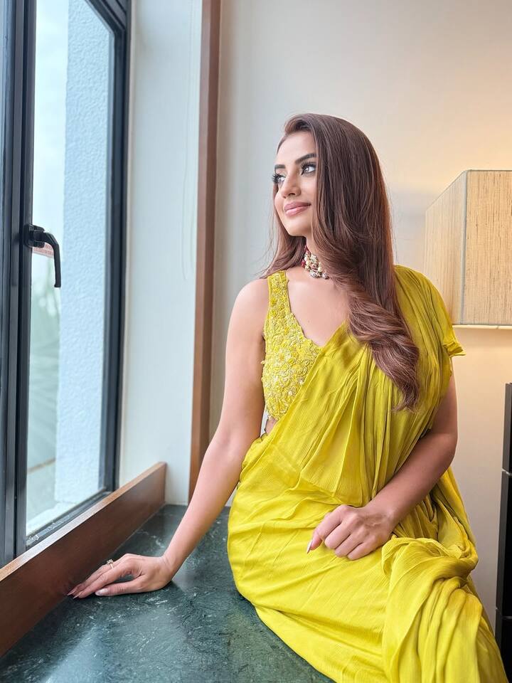 इस लुक में अक्षरा ने पीले रंग की सुंदर साड़ी पहनी है, जिसके साथ उन्होंने मैचिंग डिज़ाइनर ब्लाउज़ कैरी किया है. साड़ी का हल्का और फ्लोई फैब्रिक है. उन्होंने अपने बाल खुले रखे हैं और सॉफ्ट वेव्स में सेट किए हैं. गले में एक एलिगेंट नेकपीस पहना है. उनका मेकअप बहुत नैचुरल और सटल है, जिसमें न्यूड लिपस्टिक और डिफाइंड आईज़ शामिल हैं.