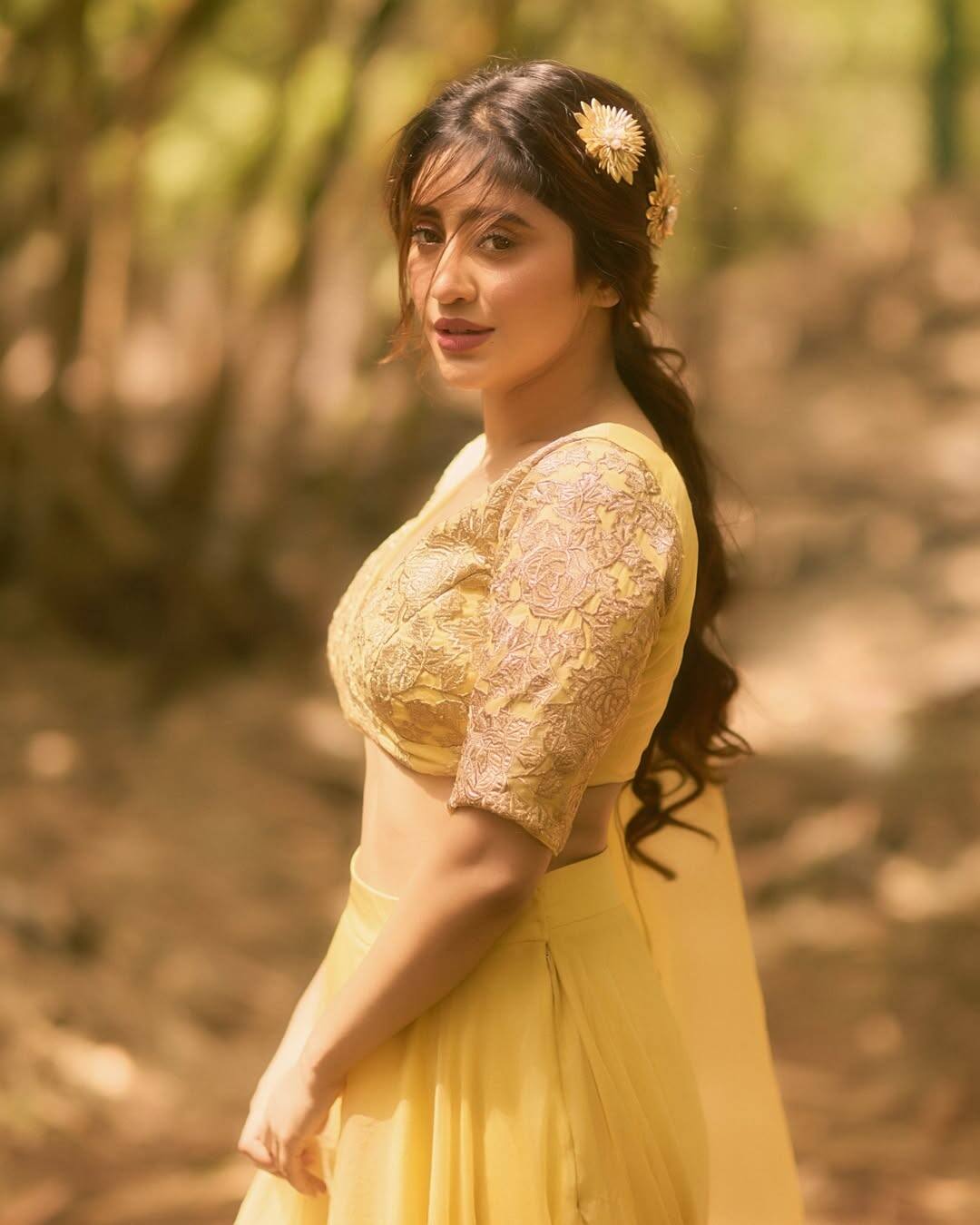 In this look, Shivangi is wearing a beautiful yellow outfit. Their blouse is embroidered with light golden threads and is accompanied by a floi yellow skirt. He has tied a little bit of hair accessory in it while keeping the hair open and has a hair accessory of flowers. Light makeup, nude lipstick and her soft smile are completing this entire look. In this look, Shivangi Ferry is giving vibe.