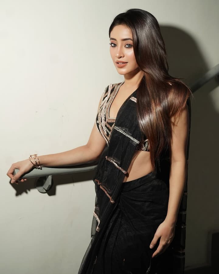 In this look, Shivangi is wearing a beautiful black sari, on which a light golden and silver border work has been done, which is making it even more stylish. There is also a design on the matching blouse with a saree. He has left his hair open in straight and shiny style. She has completed the look with nude makeup, light eyeshadow and nude lipstick.