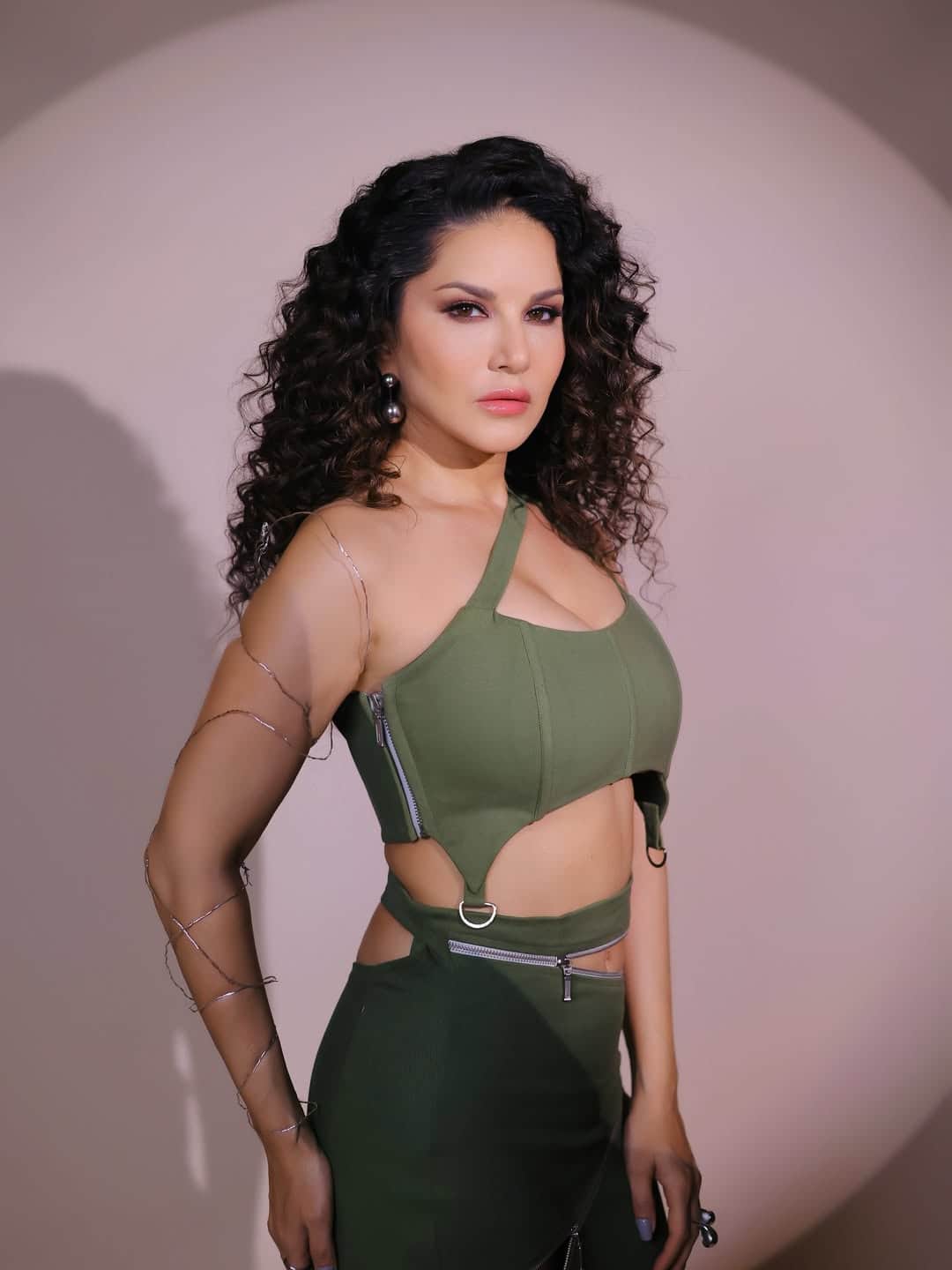 This look looks quite stylish. In this look, Sunny is wearing an olive green cut-out dress, which is carried with curly hair and nude makeup.
