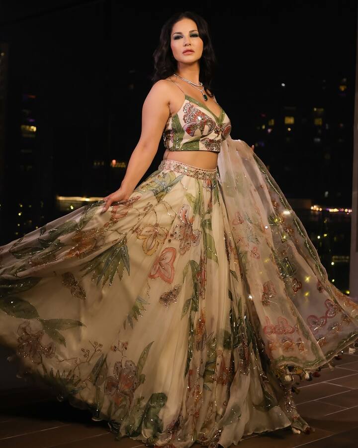 इस लुक में सनी ने ऑर्गेन्ज़ा का कलरफुल लहंगा पहना है, जिसमे बड़े- बड़े फ्लॉरल डिज़ाइन बने है. इस लुक को पूरा करने के लिए उन्होंने स्टेटमेंट नेकलेस और चंकी ब्रेसलेट, इयरिंग और रिंग पहनी है. इस लुक को उन्होंने कर्ली हेयरस्टाइल के साथ स्टाइल किया है.