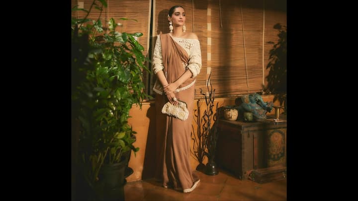 2. Sonam Kapoor: Sonam Kapoor: Sonam Kapoor redefined ethnic fashion by wearing this fit which is nothing short of contemporary. The earthy brown drape was styled with an off-shoulder crochet blouse, a modern pairing that instantly elevated the timeless sari silhouette. Sonam added more character by pairing it with a chic clutch and statement earrings. (Image Source: Instagram/@sonamkapoor)