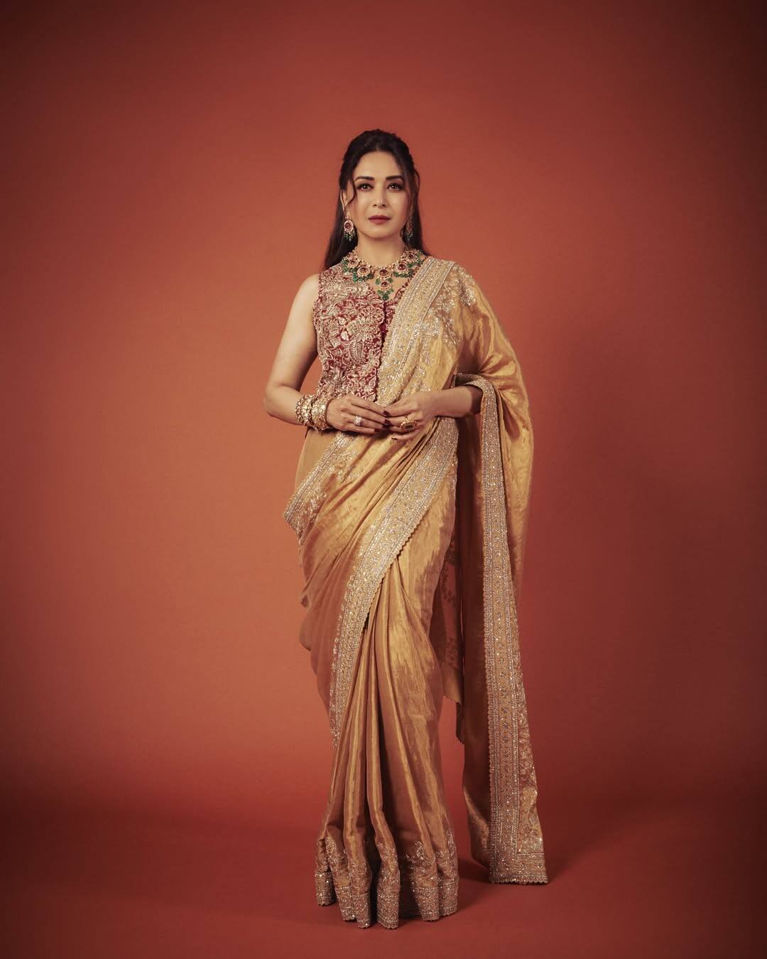 It is a high-neck, sleeveless blouse in which the entire front is covered with heavy embroidery work. Its design is so rich and detailed that this blouse itself becomes a statement piece. If you wear such blouse with a plane or light work saree, then look and look. This blouse is giving a corset look.