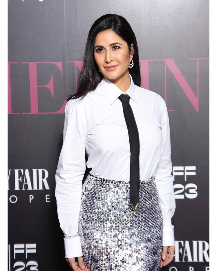 In this picture, Katrina is wearing a black tie and silver sequin skirt with a white shirt, making her style sharp and elegant. Strait hair, minimal makeup and statement earrings are making their look more polished.