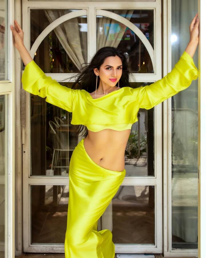 Akanksha looks glamorous in this yellow dress. His confident pose with open hair and makeup is very elegant.