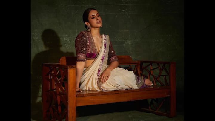 2. Sanya Malhotra: Sanya Malhotra is known for her experimental yet elegant fashion choices. She chose a pristine ivory saree with subtle detailing and amped up the drama with a deep-neck, heavily embroidered velvet blouse in jewel tones of plum and gold. The contrast instantly elevated her outfit, giving it a modern yet royal vibe. Statement jhumkas, minimal makeup, and a sleek bun added the perfect finishing touches. (Image Source: Instagram/@sanyamalhotra_)