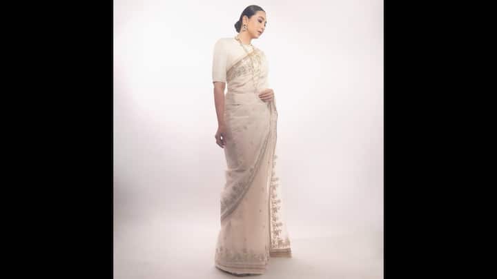 1. Karisma Kapoor: Karisma Kapoor radiated old-world charm in an ethereal ivory saree with delicate silver and floral embroidery. She paired the saree with a classic blouse and elevated the look with layers of statement pearl jewellery, adding just the right amount of regal sophistication. With her hair styled in a sleek bun and minimal makeup highlighting her striking features, Karisma proves that simplicity in white can be incredibly powerful. (Image Source: Instagram/@therealkarismakapoor)