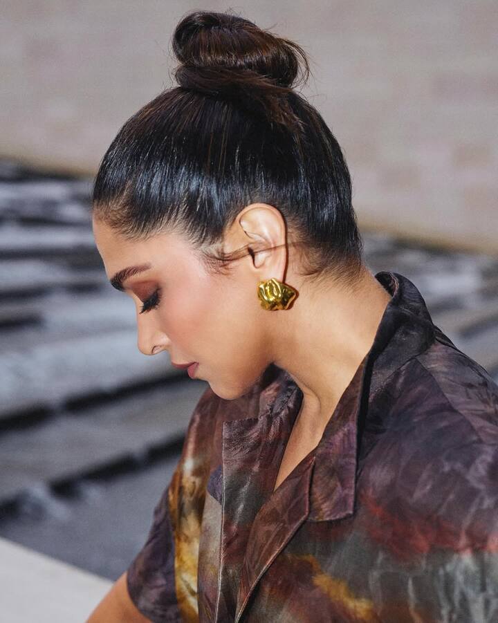 She accessorized the look with golden stud earrings, chic black heels, and a stylish handbag.