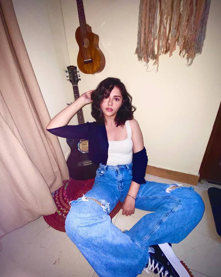 Anit has kept this look casual. She is wearing blue ripped jeans with a white top which is giving her a trendy and cool look. He has completed the look with black sneakers and open hair.