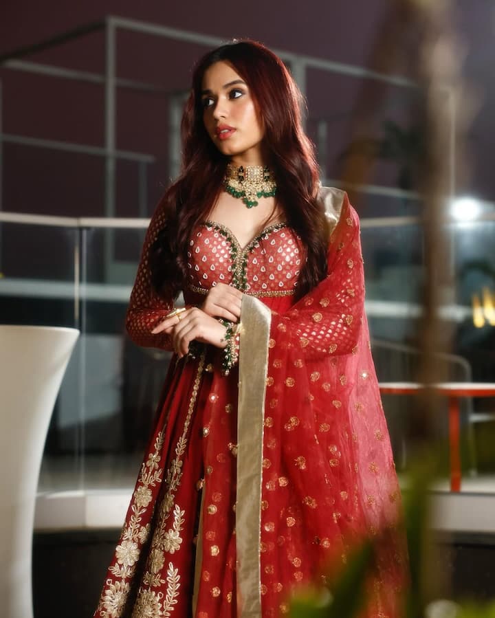 The paradise wearing a red color Anarkali frock looks gorgeous. The actress has done heavy green jewelery pair with red dress.