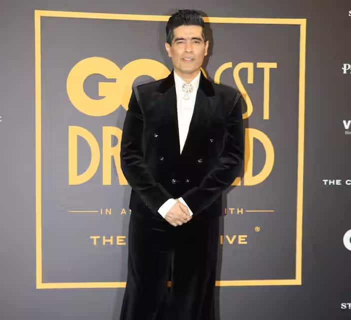 फैशन डिज़ाइनर मनीष मल्होत्रा ​​ने इस इवेंट में काले रंग का वेलवेट सूट पहना था। उन्होंने अपने लुक को सफ़ेद शर्ट और ब्रोच डिटेलिंग के साथ पूरा किया।