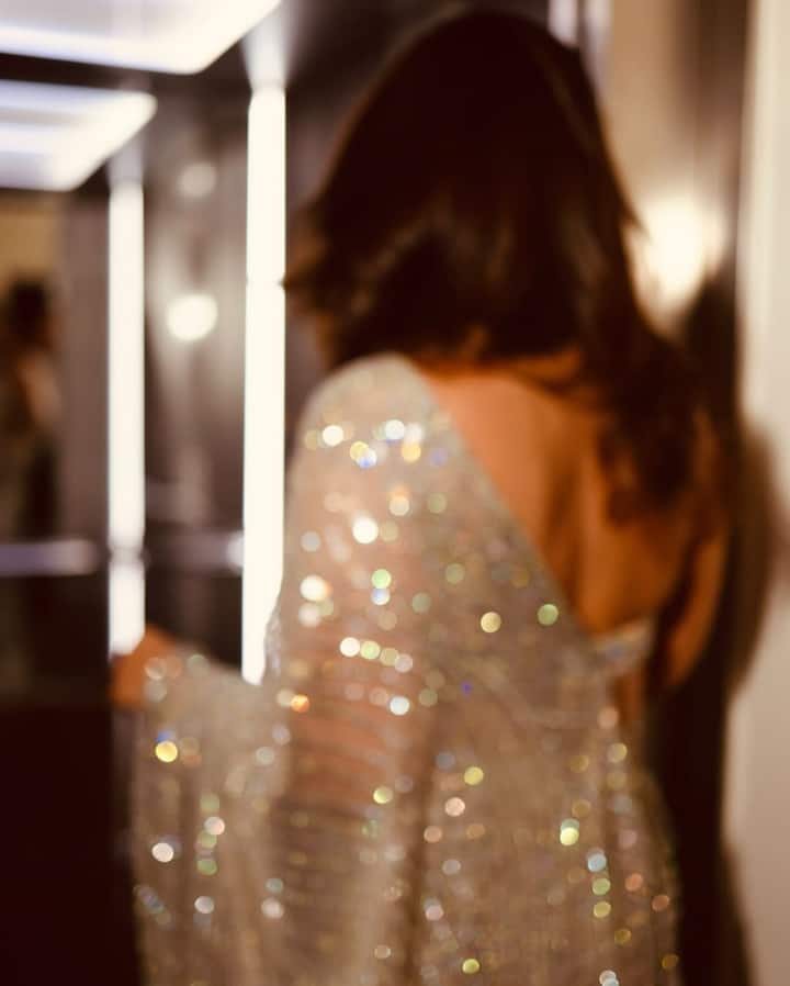 Kareena accessorized the look with statement chandelier earrings that mirrored the shimmer of her saree. She kept it classy with a set of slim diamond bangles and skipped the necklace to let the halter neckline shine. A sleek metallic clutch peeked through in one of the shots, complementing the overall palette.