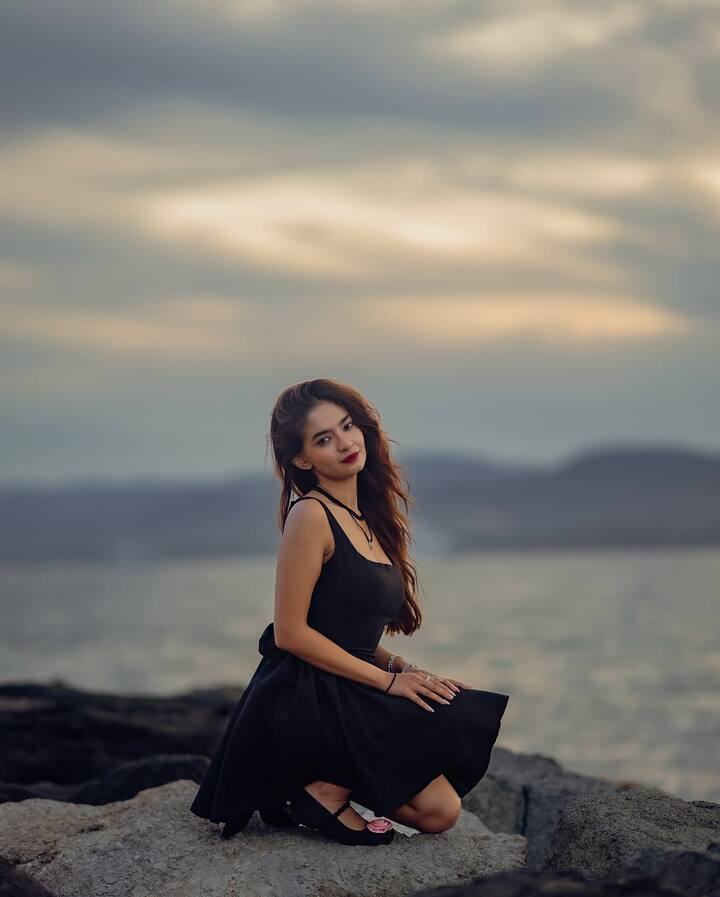 The seaside backdrop with rocks and waves amplified the look’s elegance.