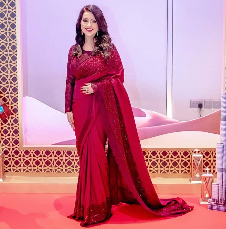 रेड कलर की साड़ी के साथ मरूम फुल स्लीव्स ब्लाउज अमृता फडणवीस पर काफी जच रहा है.