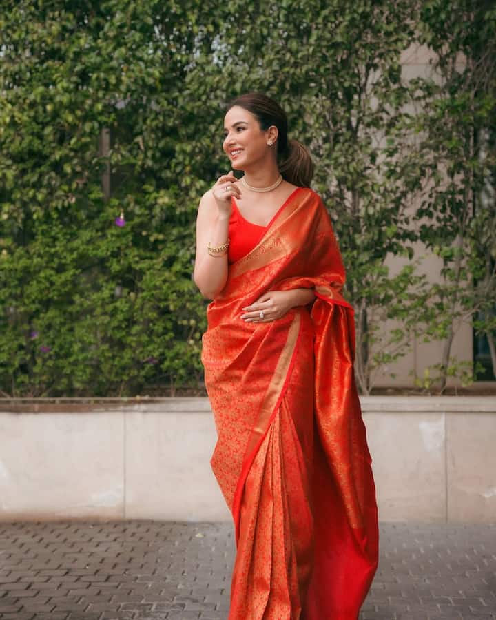 In this look, Jasmine Traditional Eligence is seen spreading. She is wearing a sleeveless blouse with a red silk saree, which is styled with minimal jewelery - Chokar necklace, bracelets and stud earrings. Simple makeup and tied hair are fulfilling their graceful and royal style.