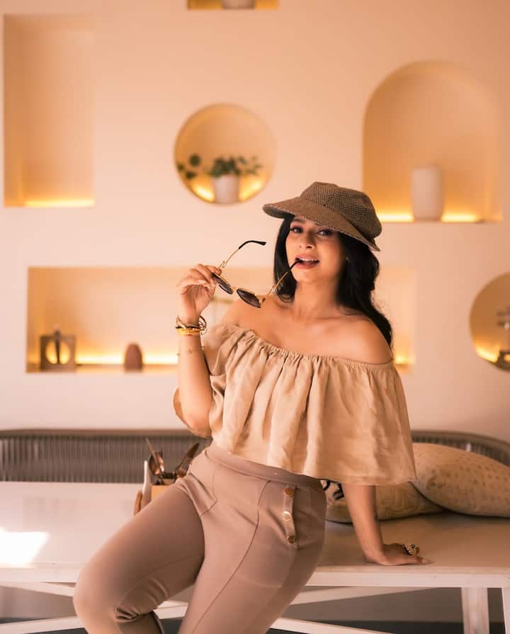 This picture of Tanisha is giving quite a casual wibe. He is wearing a beige off-shoulder top and matching pants. He has given cool and trendy touch to his look with cap, sunglasses and minimal jewelery.