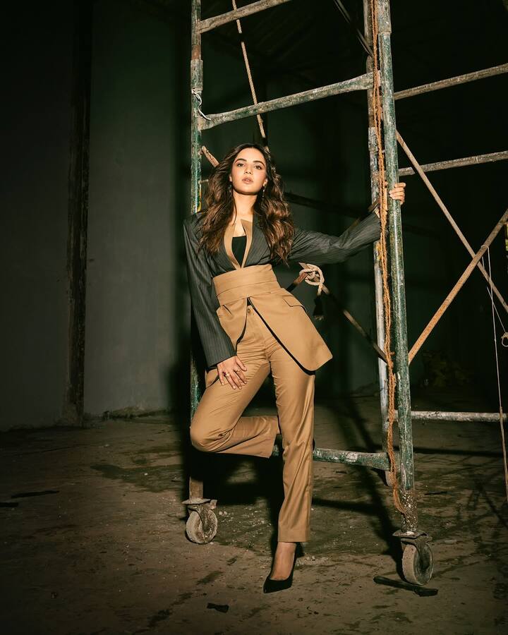This look of Jasmine Bhasin is very stylish and powerful. He is wearing a brown high-wasted pants with a black blazer, giving him boss lady vibe. Open wavy hair and nude makeup are making their look more elegant. This look shows both confidence and glamor.