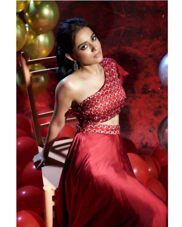 अमृता ने इस लुक में फेस्टिव वाईब अपनाया है. उन्होंने रेड वन-शोल्डर ब्लाउज़ और फ्लोई स्कर्ट पहनी है, जिस पर मिररवर्क और सीक्विन डिटेलिंग है. खुले बालों के बजाय उन्होंने हेयरस्टाइल को टाई किया है, और लंबे झुमके उनके लुक को और भी ग्रेसफुल बना रहे हैं.