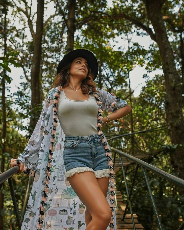This look of Shriya is very cool and full of travel vibes. He is wearing a white tank top and denim shorts, on which the printed long shrug is giving stylish touch. Black hat, open hair and minimal jewelery are making their casual outfits even more trendy.