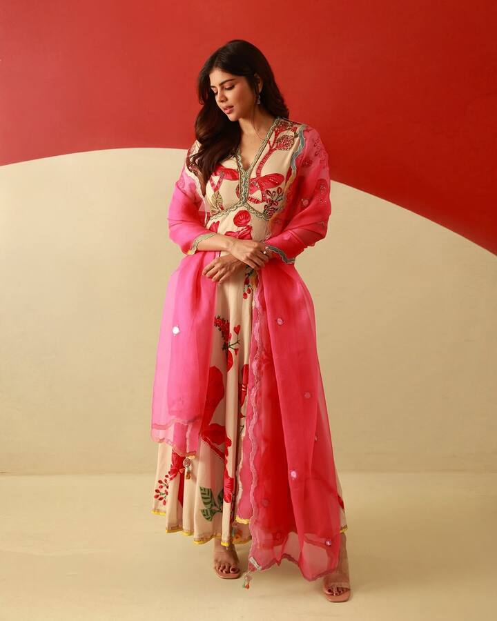 कल्याणी का ये लुक बहुत ही फ्रेश और एलिगेंट है. उन्होंने ऑफ-व्हाइट बेस पर कलरफुल फ्लोरल प्रिंट वाला अनारकली सूट पहना है, जिसे पिंक दुपट्टे के साथ मैच किया है. हल्की ज्वेलरी और नैचुरल मेकअप इस ट्रेडिशनल लुक को और भी ग्रेसफुल बना रहे हैं.