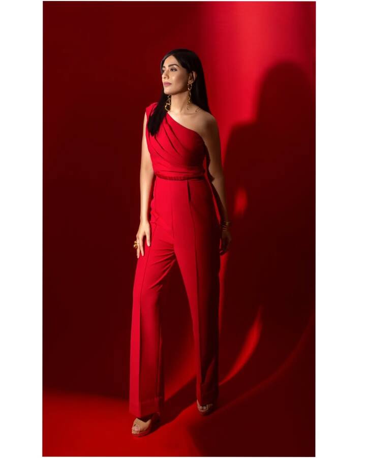 इस तस्वीर में अमृता ने रेड वन-शोल्डर जंपसूट पहना है. स्ट्रेट फिट पैंट्स और ड्रेप स्टाइल टॉप उन्हें एलिगेंट और मॉडर्न वाइब दे रहा है. गोल्डन ज्वेलरी और न्यूड हील्स ने पूरे लुक को रॉयल टच दिया है.